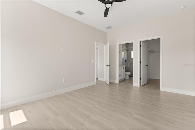 811 E Mcdonald Ave, Eustis, FL 32726 - unfurnished bedroom featuring light wood-style floors, baseboards, a spacious closet, and ensuite bathroom