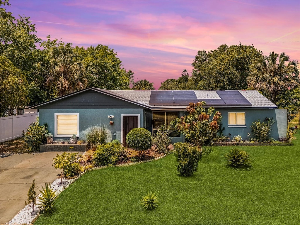 1872 Wayside Dr, Orlando, FL 32818 - ranch-style home with roof mounted solar panels, roof with shingles, and stucco siding