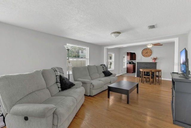 232 E Grant St, Orlando, FL 32806 - living area with a textured ceiling, light wood-style flooring, ceiling fan, and baseboards