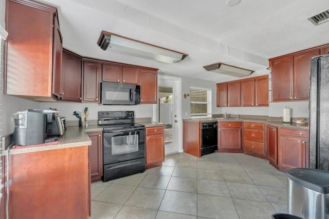 232 E Grant St, Orlando, FL 32806 - kitchen with black appliances, light countertops, light tile patterned flooring, and a sink