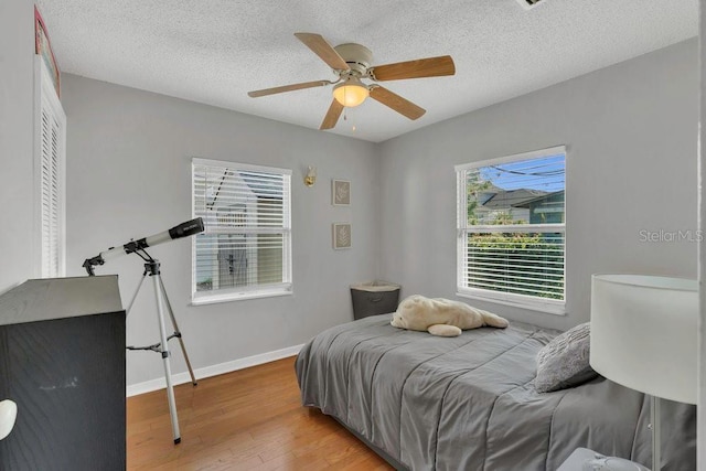 232 E Grant St, Orlando, FL 32806 - bedroom with wood finished floors, baseboards, ceiling fan, and a textured ceiling
