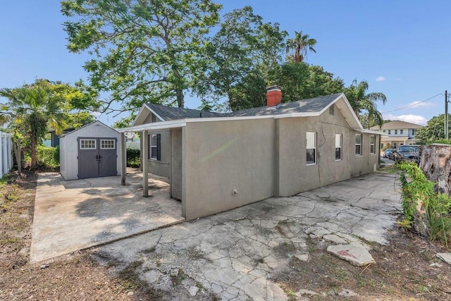 232 E Grant St, Orlando, FL 32806 - back of house featuring a patio area, stucco siding, and a chimney