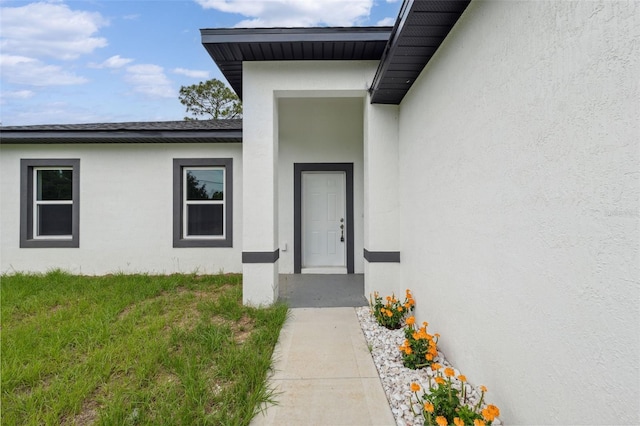 10218 N Langdon Rd, Citrus Springs, FL 34434 - doorway to property featuring stucco siding and a lawn