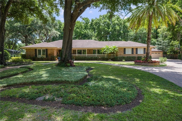 2009 Woody Dr, Windermere, FL 34786 - ranch-style home with driveway, a front yard, brick siding, and a garage