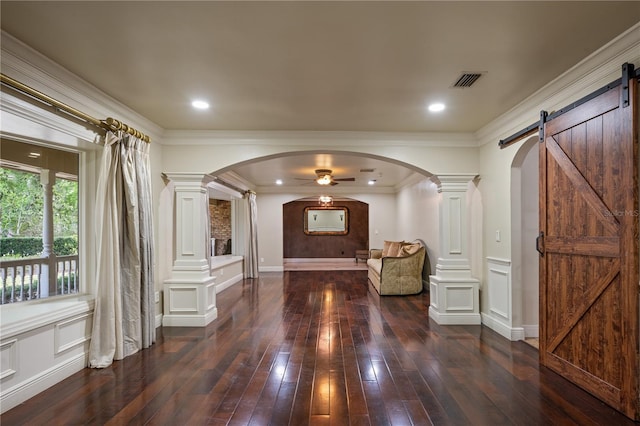2009 Woody Dr, Windermere, FL 34786 - foyer featuring decorative columns, arched walkways, a barn door, dark wood finished floors, and crown molding