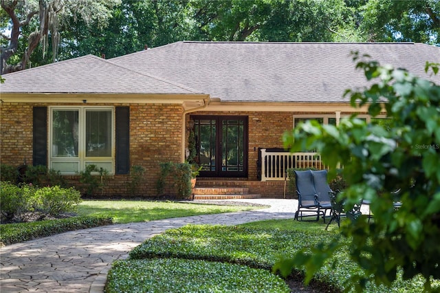 2009 Woody Dr, Windermere, FL 34786 - entrance to property with brick siding, a yard, and a shingled roof