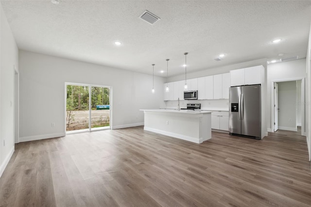 2565 W Laredo Dr, Citrus Springs, FL 34433 - kitchen featuring appliances with stainless steel finishes, recessed lighting, a textured ceiling, an island with sink, and wood finished floors