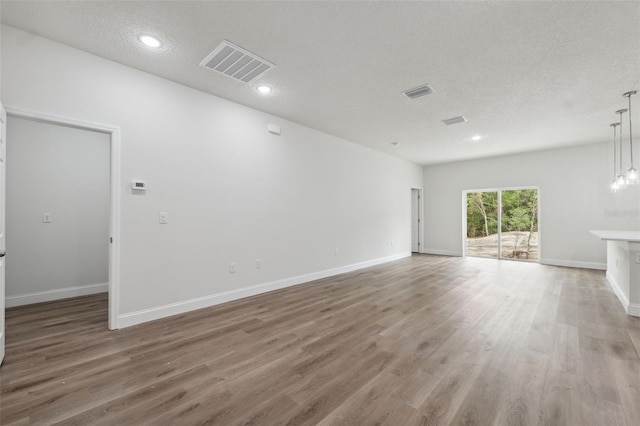 2565 W Laredo Dr, Citrus Springs, FL 34433 - unfurnished living room with light wood-style flooring, baseboards, a textured ceiling, and recessed lighting
