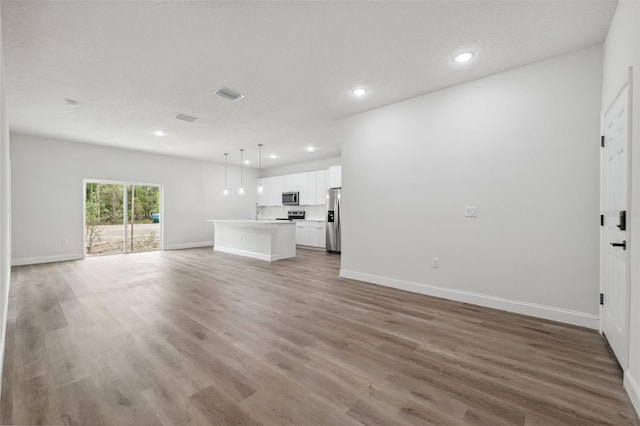 2565 W Laredo Dr, Citrus Springs, FL 34433 - unfurnished living room featuring recessed lighting, baseboards, light wood-style flooring, and a sink