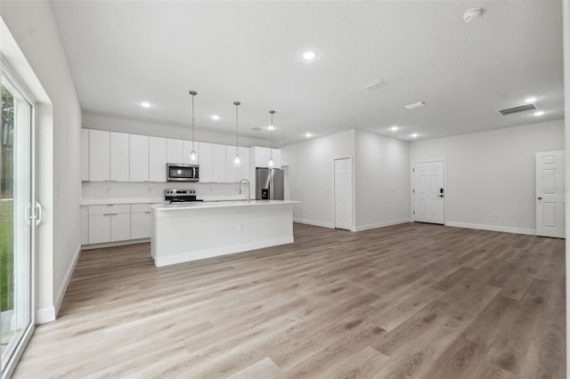 2565 W Laredo Dr, Citrus Springs, FL 34433 - kitchen featuring appliances with stainless steel finishes, recessed lighting, a center island with sink, open floor plan, and white cabinets