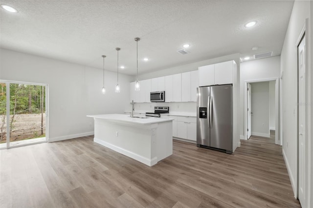 2565 W Laredo Dr, Citrus Springs, FL 34433 - kitchen featuring stainless steel appliances, a textured ceiling, baseboards, an island with sink, and light wood-style floors