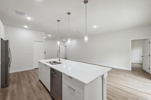 2565 W Laredo Dr, Citrus Springs, FL 34433 - kitchen featuring stainless steel appliances, a sink, light wood finished floors, a center island with sink, and white cabinets