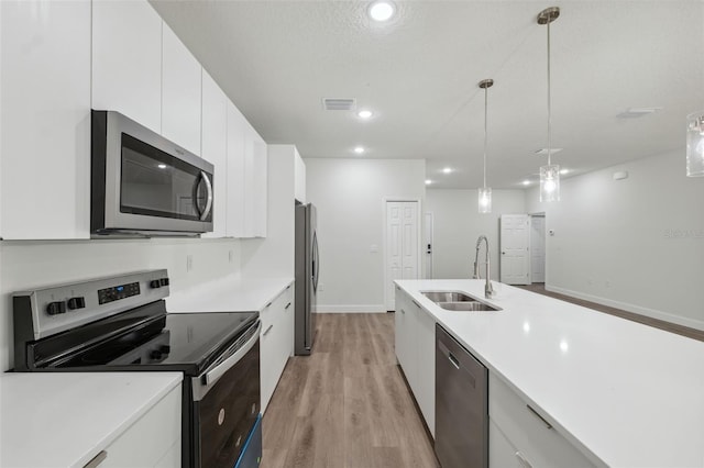 2565 W Laredo Dr, Citrus Springs, FL 34433 - kitchen featuring stainless steel appliances, a sink, light wood-type flooring, white cabinetry, and light countertops