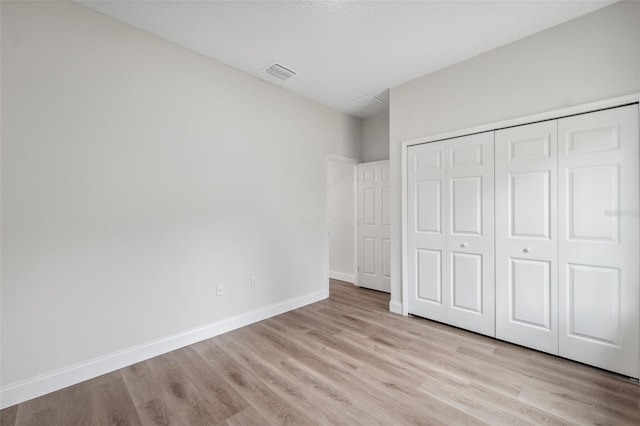 2565 W Laredo Dr, Citrus Springs, FL 34433 - unfurnished bedroom with light wood-type flooring, baseboards, and a closet