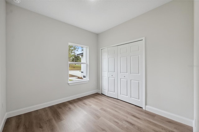 2565 W Laredo Dr, Citrus Springs, FL 34433 - unfurnished bedroom with light wood-style flooring, baseboards, and a closet