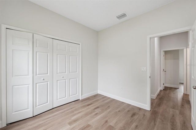 2565 W Laredo Dr, Citrus Springs, FL 34433 - unfurnished bedroom with light wood-style floors, baseboards, and a closet