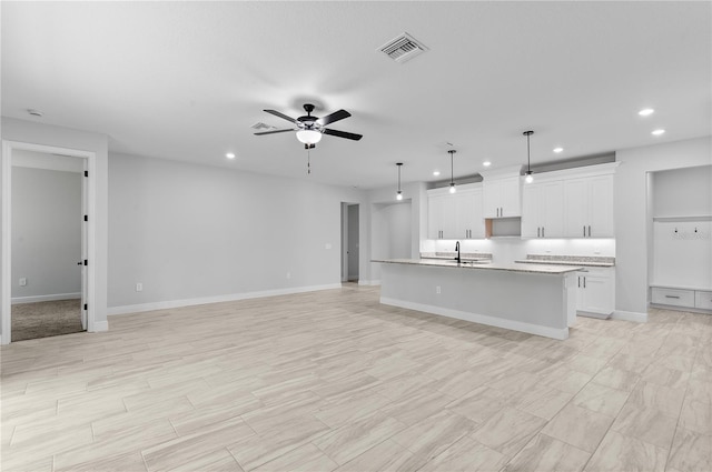 30369 Apricot Ave, Eustis, FL 32736 - kitchen featuring recessed lighting, a center island with sink, open floor plan, ceiling fan, and white cabinets