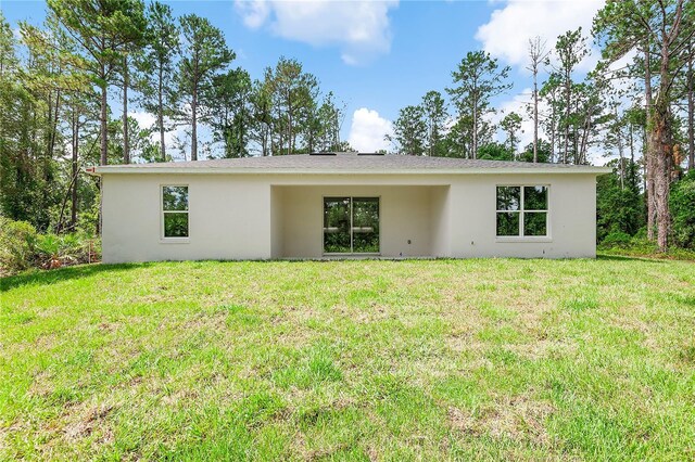 30369 Apricot Ave, Eustis, FL 32736 - rear view of property featuring stucco siding and a lawn