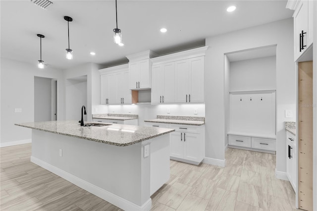 30369 Apricot Ave, Eustis, FL 32736 - kitchen featuring white cabinetry, light stone counters, a kitchen island with sink, decorative light fixtures, and recessed lighting