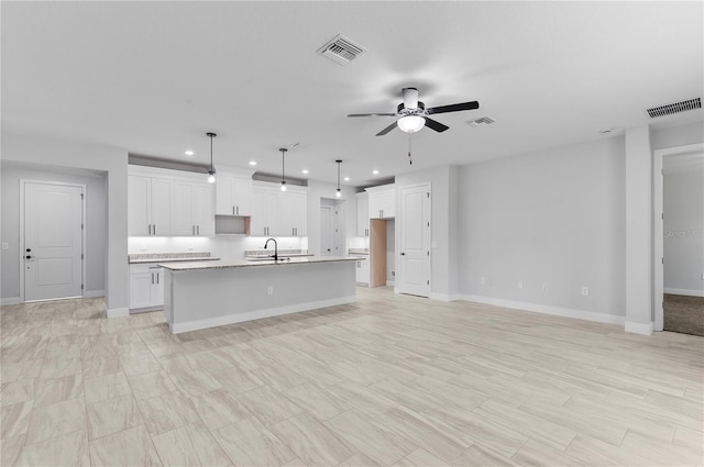 30369 Apricot Ave, Eustis, FL 32736 - kitchen featuring recessed lighting, a ceiling fan, white cabinets, a kitchen island with sink, and light countertops