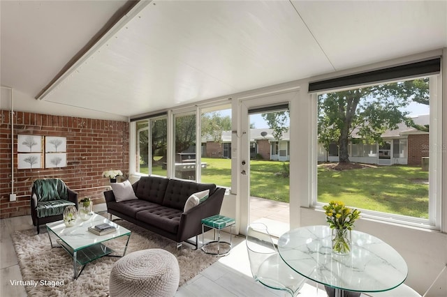 1230 Americana Pl, Orlando, FL 32807 - sunroom featuring healthy amount of natural light, wood finished floors, and brick wall