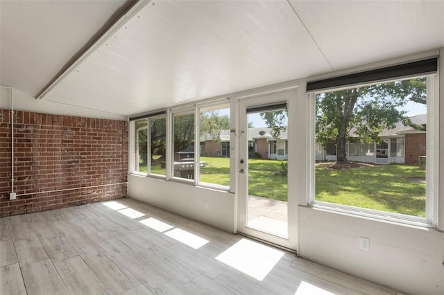 1230 Americana Pl, Orlando, FL 32807 - unfurnished sunroom with brick wall and wood finished floors