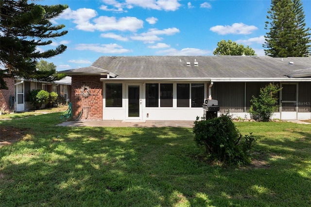 1230 Americana Pl, Orlando, FL 32807 - back of property featuring a lawn, brick siding, and a sunroom