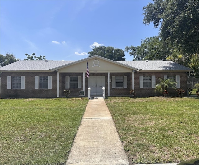 1230 Americana Pl, Orlando, FL 32807 - ranch-style house featuring a front yard and brick siding