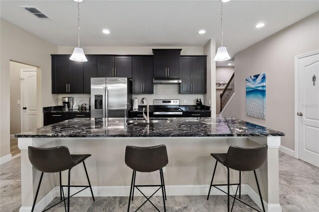 3883 Crawley Down Loop, Sanford, FL 32773 - kitchen with appliances with stainless steel finishes, dark cabinetry, baseboards, a kitchen bar, and a large island