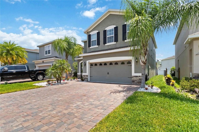 3883 Crawley Down Loop, Sanford, FL 32773 - view of front of property featuring a garage, stucco siding, stone siding, decorative driveway, and a front lawn