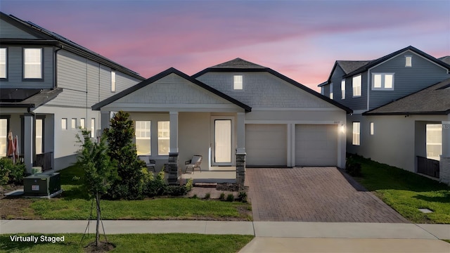 16055 Silver Brook Way, Winter Garden, FL 34787 - view of front facade featuring an attached garage, covered porch, decorative driveway, and stucco siding
