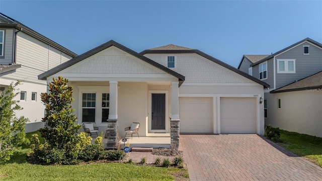 16055 Silver Brook Way, Winter Garden, FL 34787 - craftsman-style house with a garage, decorative driveway, covered porch, and stucco siding