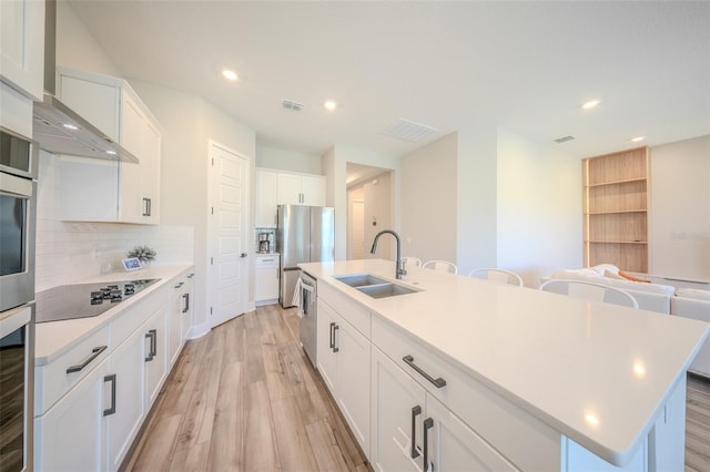 16055 Silver Brook Way, Winter Garden, FL 34787 - kitchen featuring a sink, appliances with stainless steel finishes, light wood finished floors, a kitchen island with sink, and backsplash