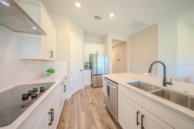 16055 Silver Brook Way, Winter Garden, FL 34787 - kitchen featuring appliances with stainless steel finishes, wall chimney range hood, a sink, light wood-type flooring, and recessed lighting