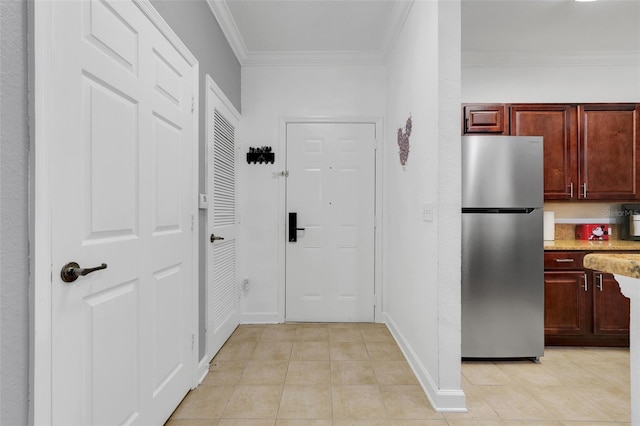 1375 Tuscana Ln Unit 1102, Davenport, FL 33896 - kitchen featuring freestanding refrigerator, light tile patterned floors, crown molding, dark brown cabinets, and baseboards