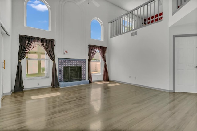 485 Whittingham Pl, Lake Mary, FL 32746 - unfurnished living room with a high ceiling, a ceiling fan, wood finished floors, and a brick fireplace