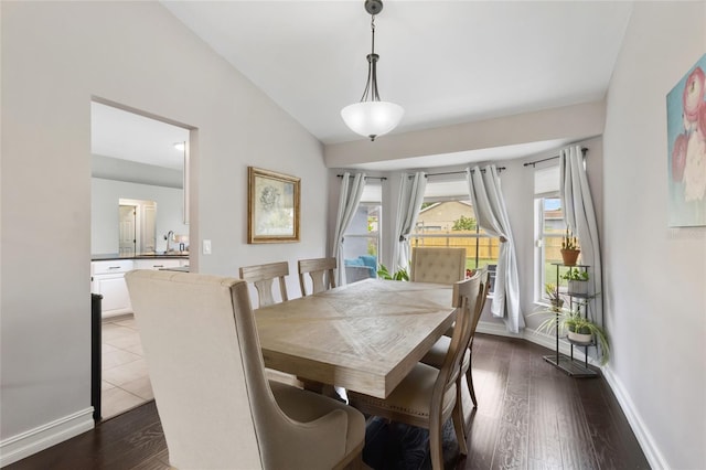 1616 Golden Poppy Ct, Orlando, FL 32824 - dining space featuring lofted ceiling, dark wood-type flooring, and baseboards