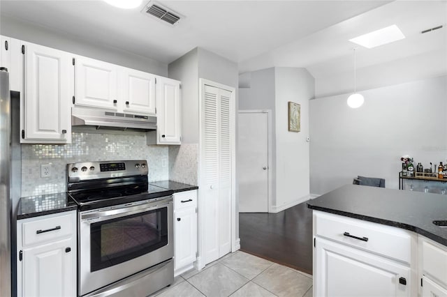 1616 Golden Poppy Ct, Orlando, FL 32824 - kitchen with electric range, exhaust hood, a skylight, white cabinets, and lofted ceiling