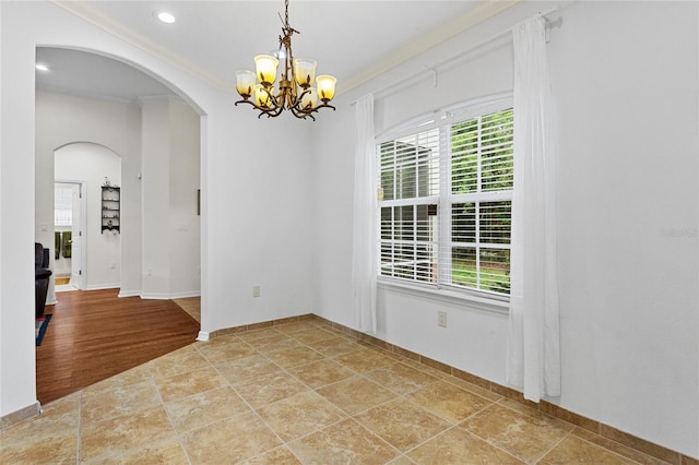 41128 Apple St, Eustis, FL 32736 - unfurnished room featuring crown molding, a chandelier, arched walkways, stone finish flooring, and baseboards