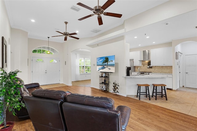 41128 Apple St, Eustis, FL 32736 - living room featuring arched walkways, ceiling fan, recessed lighting, and light wood-style floors