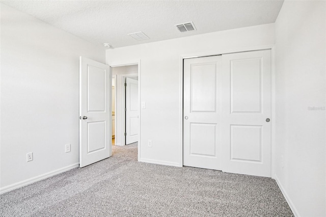 1740 Brekey Way, Zephyrhills, FL 33541 - unfurnished bedroom featuring carpet flooring, a closet, and a textured ceiling