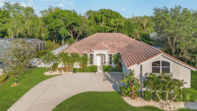 6121 Oxbow Bend Ln, Port Orange, FL 32128 - mediterranean / spanish-style house with stucco siding, a front lawn, and a tile roof