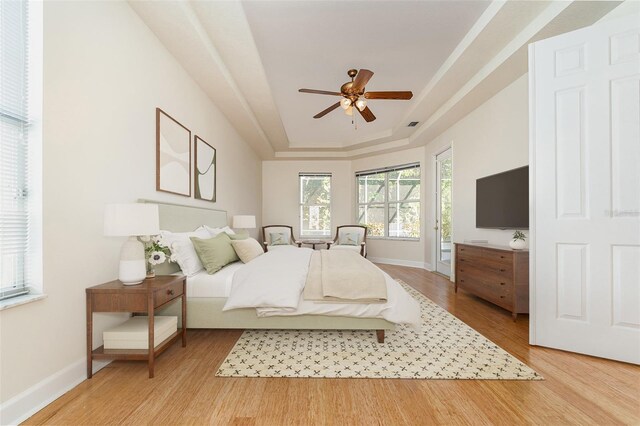 6121 Oxbow Bend Ln, Port Orange, FL 32128 - bedroom featuring a raised ceiling, light wood-style flooring, baseboards, and access to outside