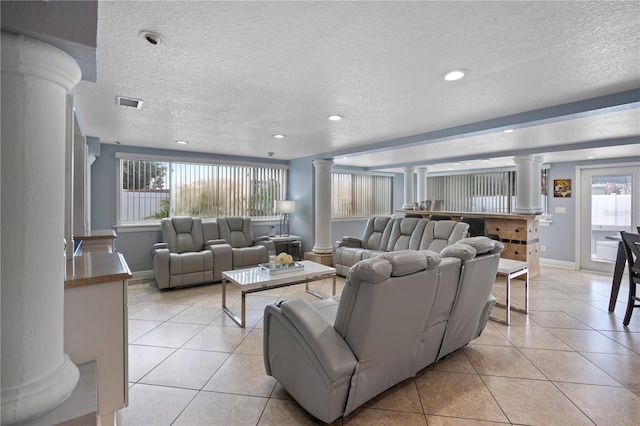 2110 W Farwell Dr, Tampa, FL 33603 - living room featuring ornate columns, light tile patterned floors, a textured ceiling, baseboards, and recessed lighting