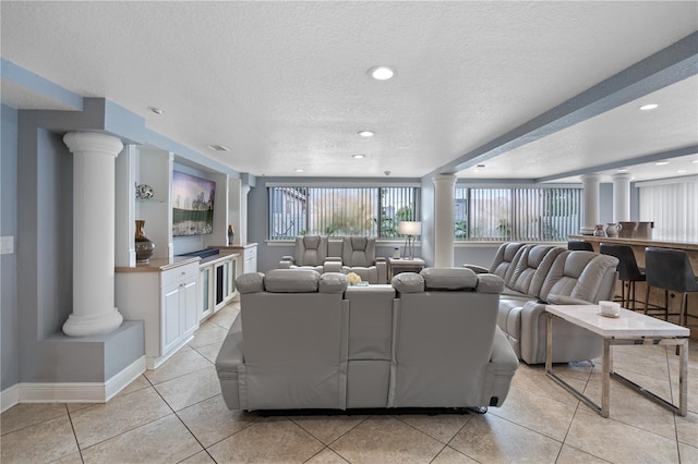 2110 W Farwell Dr, Tampa, FL 33603 - living room featuring ornate columns, a textured ceiling, baseboards, light tile patterned flooring, and recessed lighting