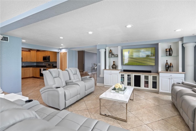 2110 W Farwell Dr, Tampa, FL 33603 - living area featuring light tile patterned flooring, recessed lighting, a textured ceiling, decorative columns, and baseboards