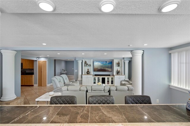 2110 W Farwell Dr, Tampa, FL 33603 - living room with decorative columns, light tile patterned floors, and a textured ceiling