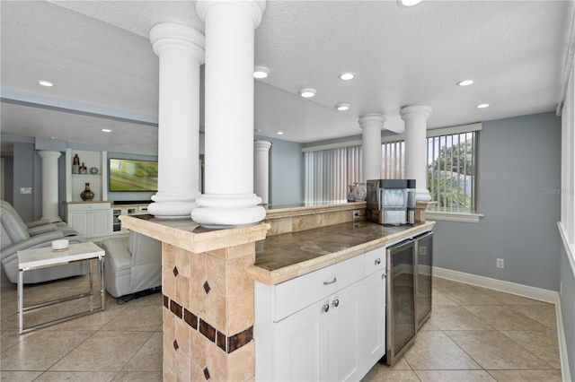 2110 W Farwell Dr, Tampa, FL 33603 - kitchen featuring beverage cooler, light tile patterned flooring, ornate columns, recessed lighting, and a textured ceiling