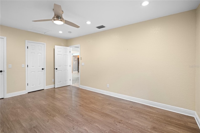 2110 W Farwell Dr, Tampa, FL 33603 - unfurnished bedroom with wood finished floors, baseboards, recessed lighting, a ceiling fan, and attic access