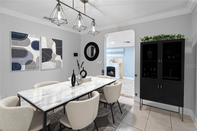 2110 W Farwell Dr, Tampa, FL 33603 - dining space with light tile patterned floors, ornamental molding, a lit fireplace, and baseboards